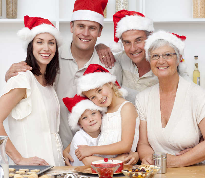 带着圣诞帽在桌前拍照的一家人