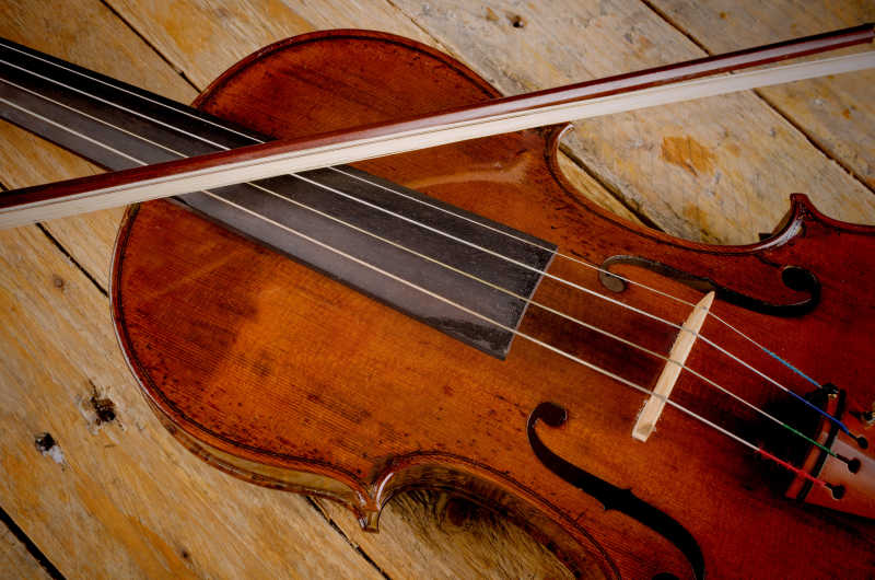 木制背景的旧小提琴和弓