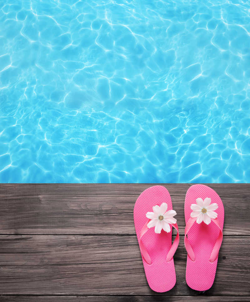 游泳池边与一双粉红色的拖鞋