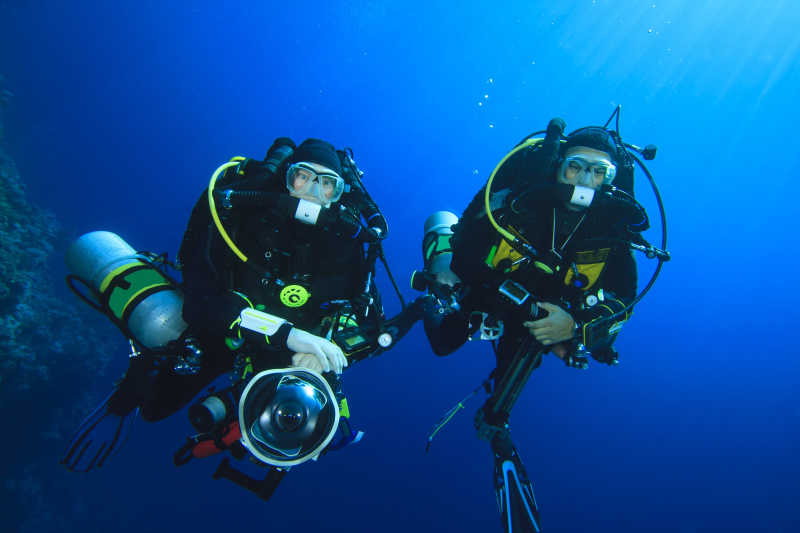 深蓝海洋中装备齐全的两名潜水员