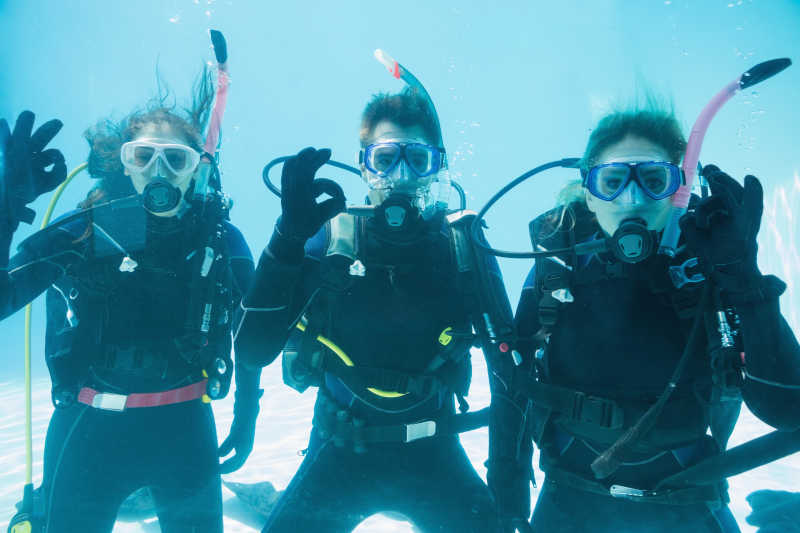 三位装备齐全的潜水员在水下