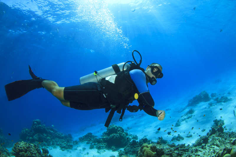 蓝色海洋中潜水的男潜水员