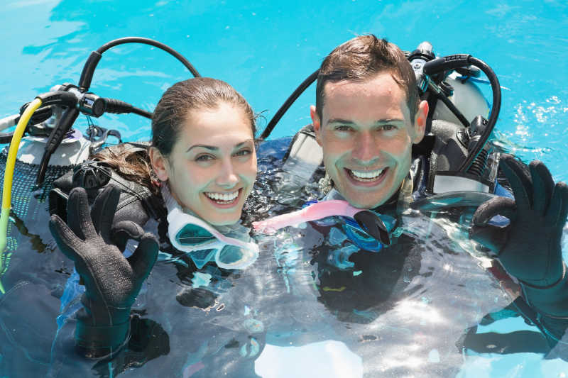 微笑的夫妇在游泳池里潜水