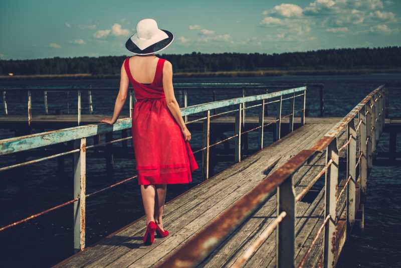码头边上的戴帽子的红裙时尚美女