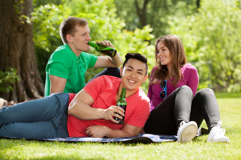 坐在公园里喝啤酒的学生