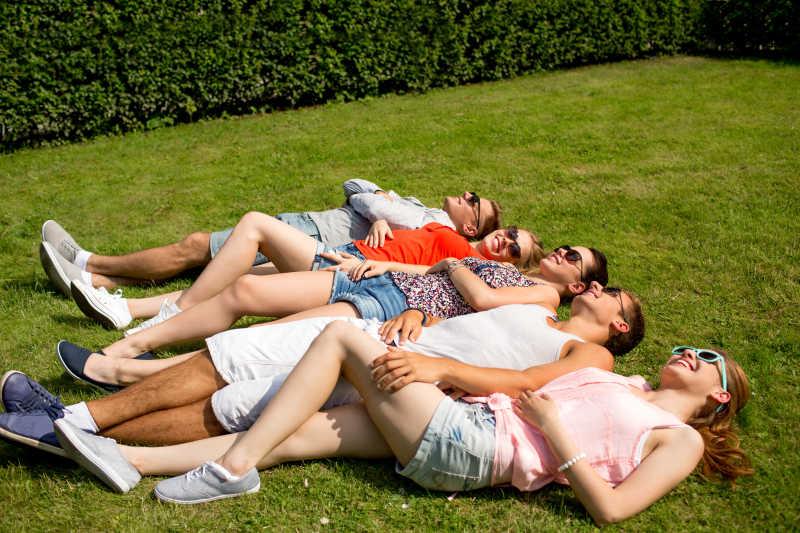 一起躺在草地上微笑的朋友们