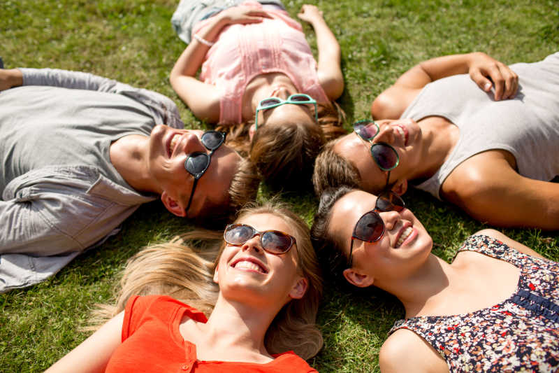 一群躺在草地上微笑着晒太阳的朋友