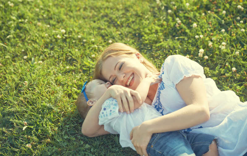 躺在草坪上的年轻母亲和小宝宝