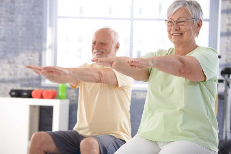 在健身房里快乐锻炼的老年夫妇
