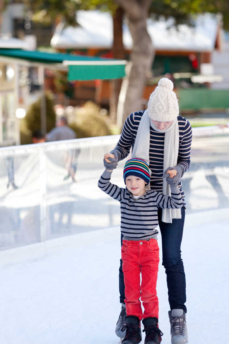 母亲带着孩子学习滑冰
