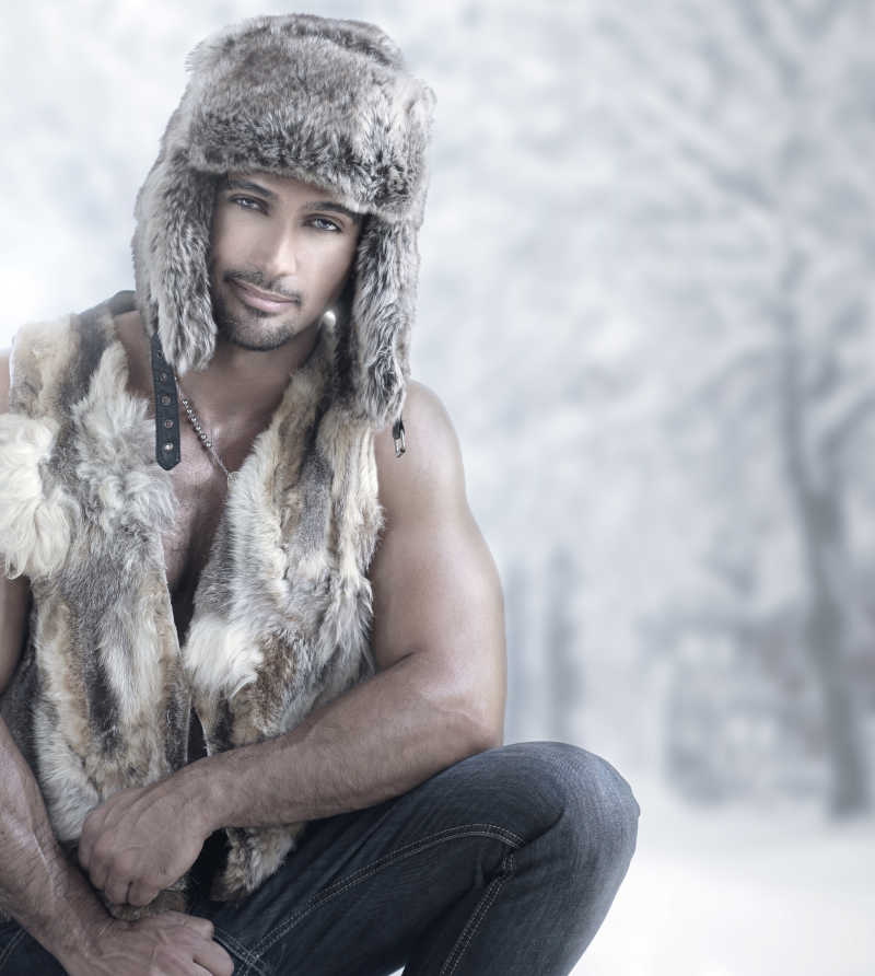 冬季雪天背景下穿戴着动物皮毛的男人