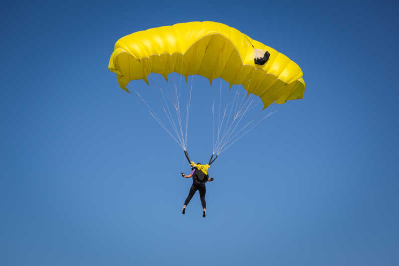 操纵者黄色降落伞的极限运动爱好者