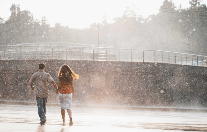 在雨中牵手散步的情侣