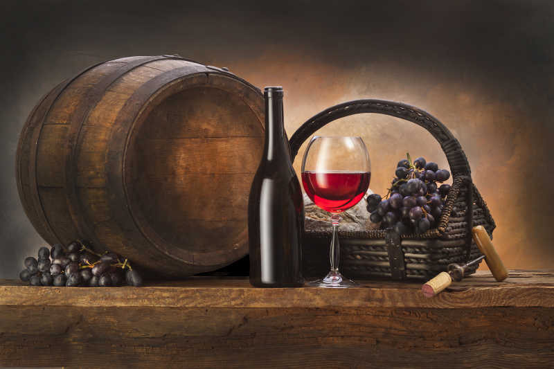 老式酒桶旁的葡萄和葡萄酒