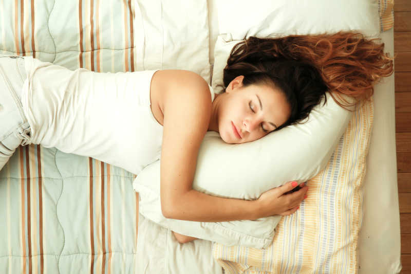 躺在床上抱着枕头睡觉的女人