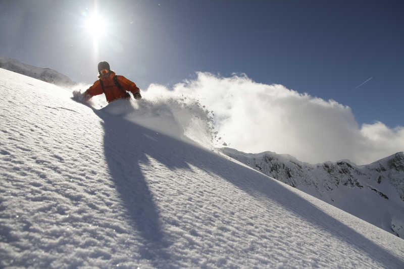 晴天阳光下雪地上正在滑雪的人