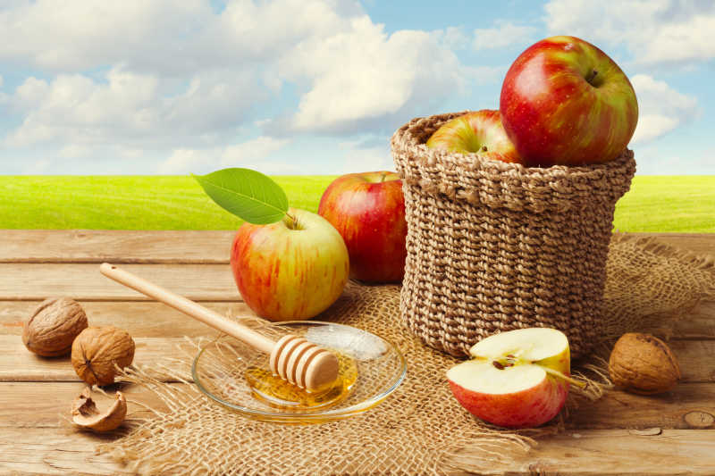 木板上的新鲜苹果与蜂蜜