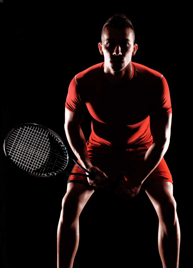黑色背景下的男网球运动员