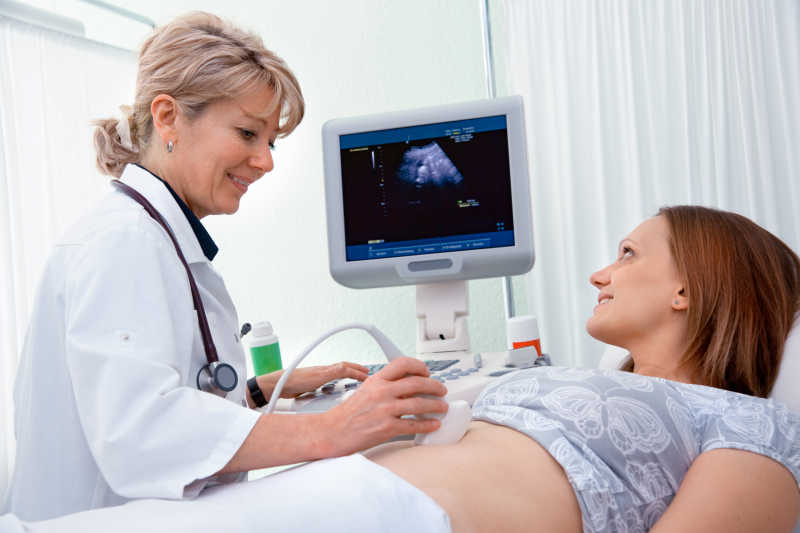 孕妇接受医生用超声诊断设备检查