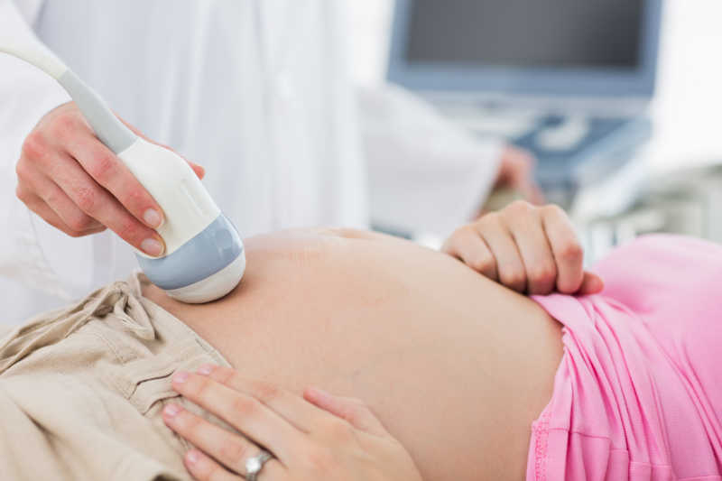 医生使用超声波探测仪探测孕妇肚子