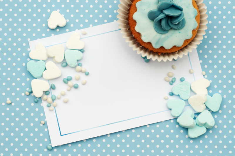 蛋糕卡背景淡蓝色的糖果心和美味蛋糕