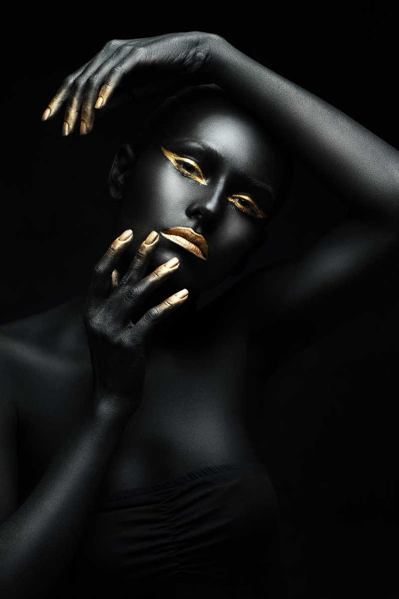 黑色背景上全身涂满黑色颜料的女人