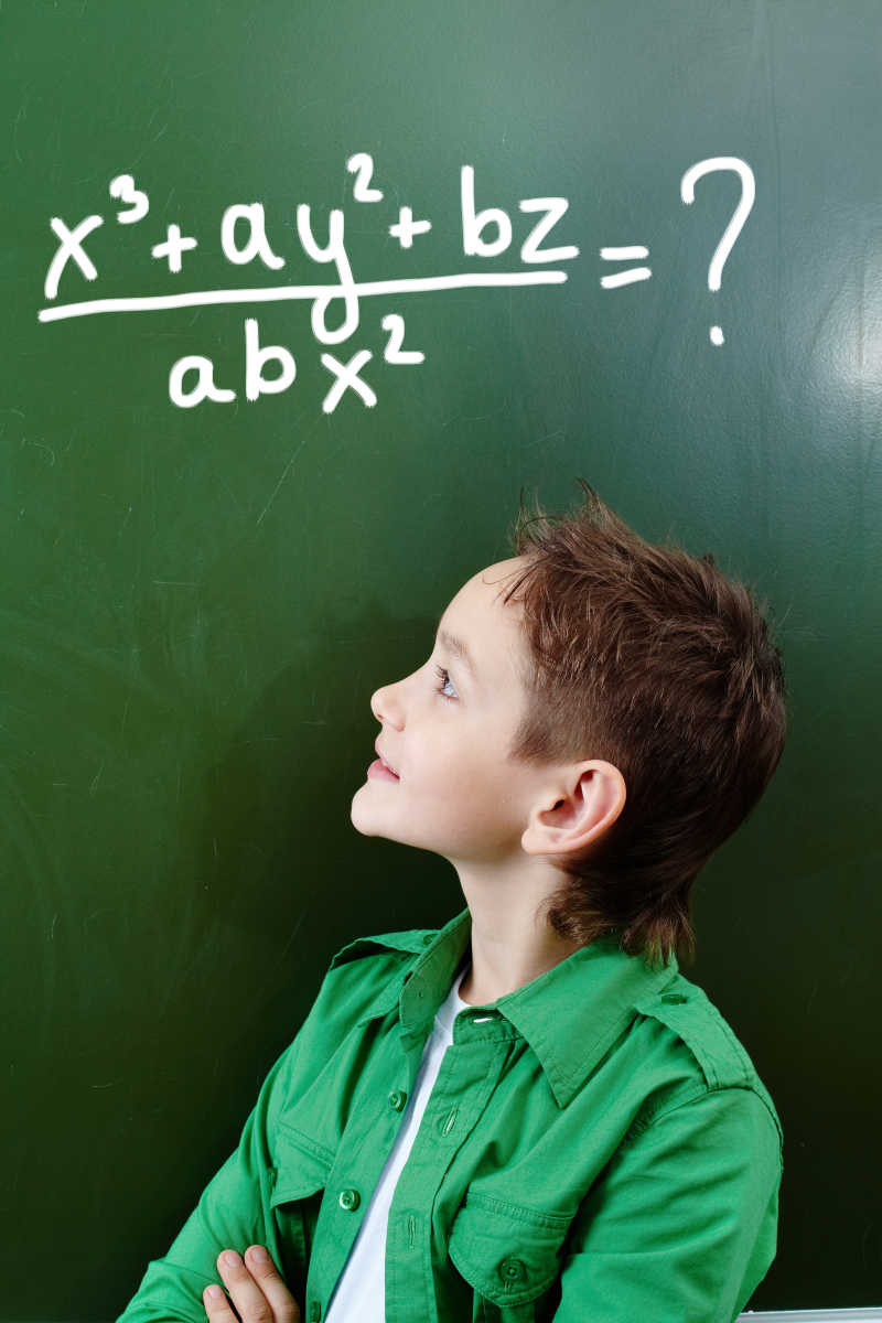 黑板前思考代数公式的小男孩