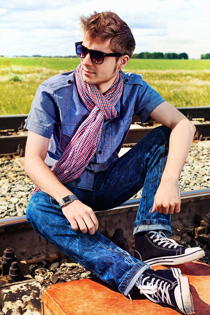 坐在铁路上的英俊青年