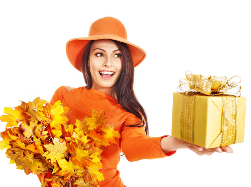 女子抱着秋天的落叶和礼品盒