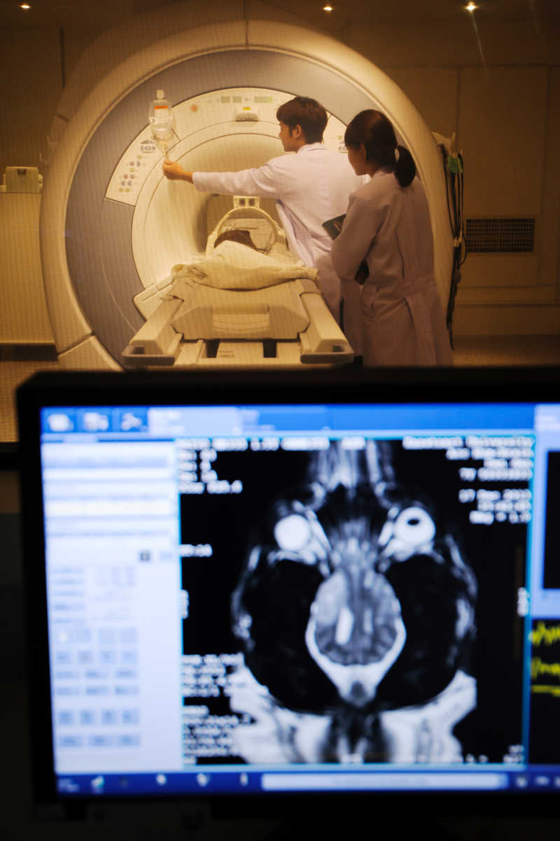 在核磁共振成像扫描仪室监控前台工作的医生