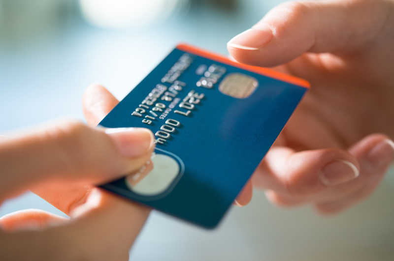 一个女人通过支付信用卡卖家特写镜头