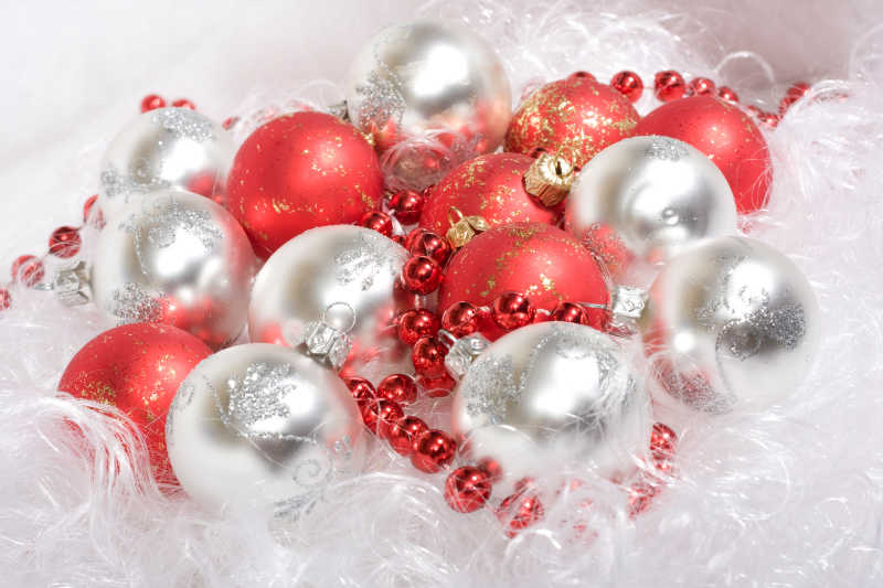 白色胡须背景上的红白圣诞球和红色珠子