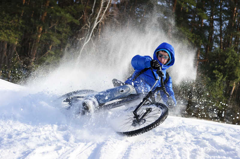 寒冬里骑自行车在雪地里的