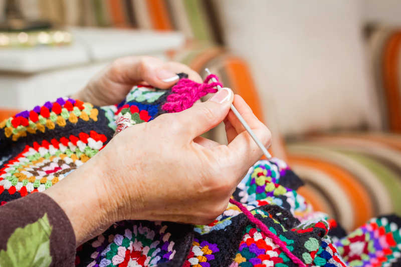 手工编织一件老式羊毛被的女人