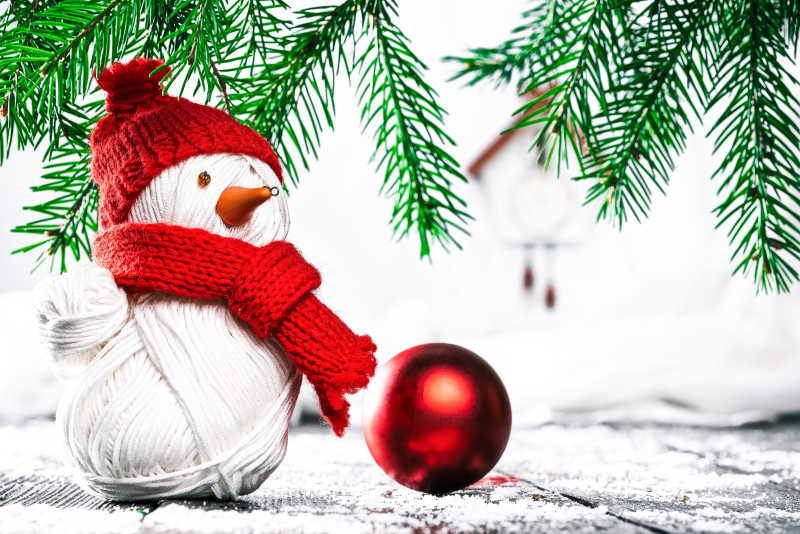 手工编织的雪人红色圣诞球在常青树枝下152231602410