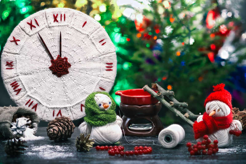 手工制作的玩具雪人和纱线束制作红浆果的珠子以及手工编织的时钟