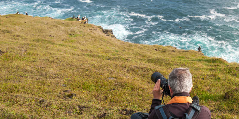 悬崖上在拍海雀的摄影师