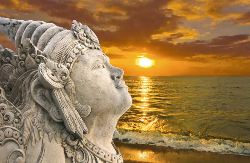 日出时海滩上的雕像