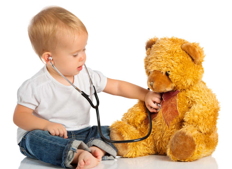 小男孩正在用听诊器给玩具熊测量心跳