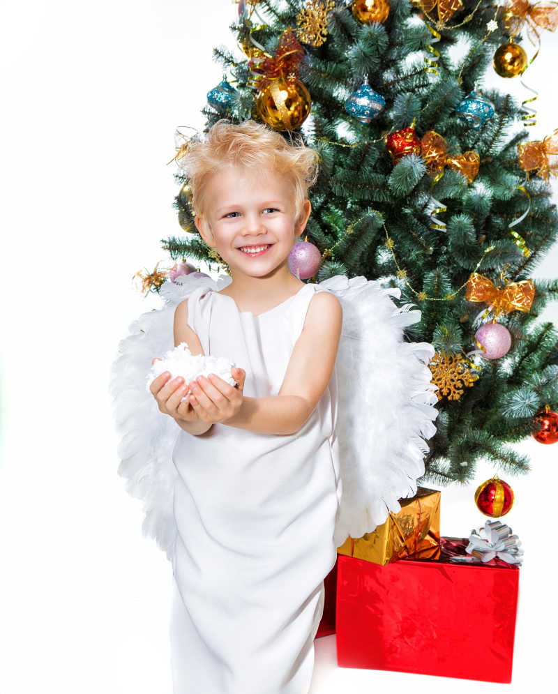 白色天使装扮的小男孩和圣诞树
