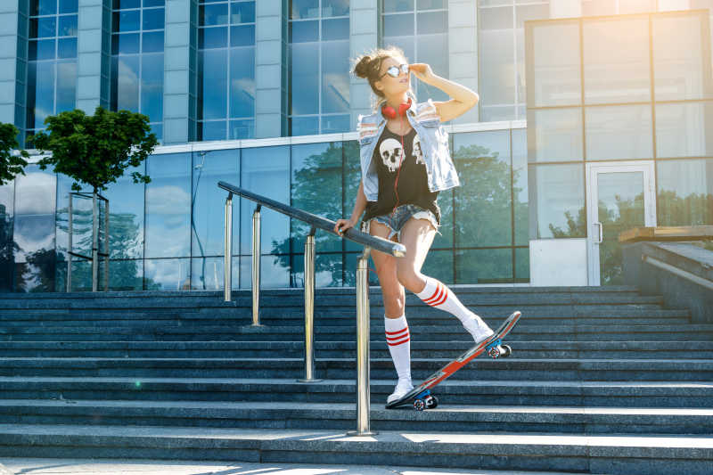 在街上玩滑板的时髦女孩