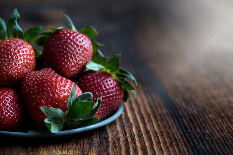 木制板上盘中成熟的草莓