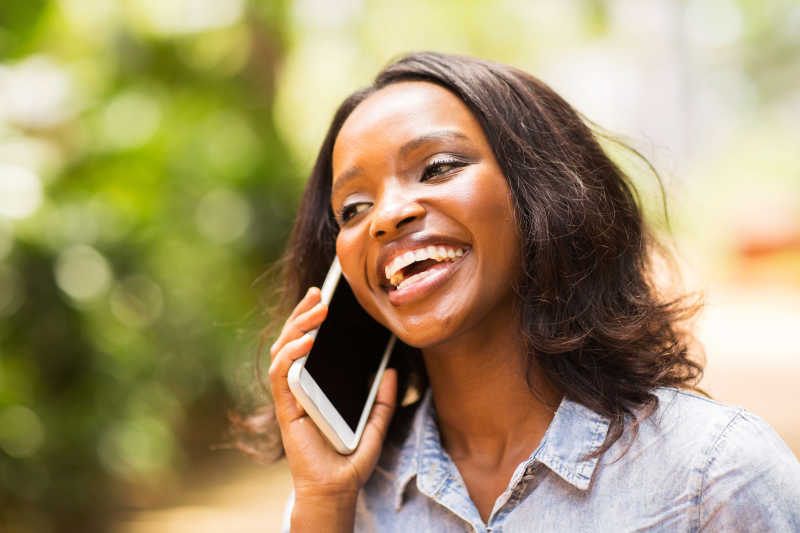 非洲年轻女子微笑的用手机通话