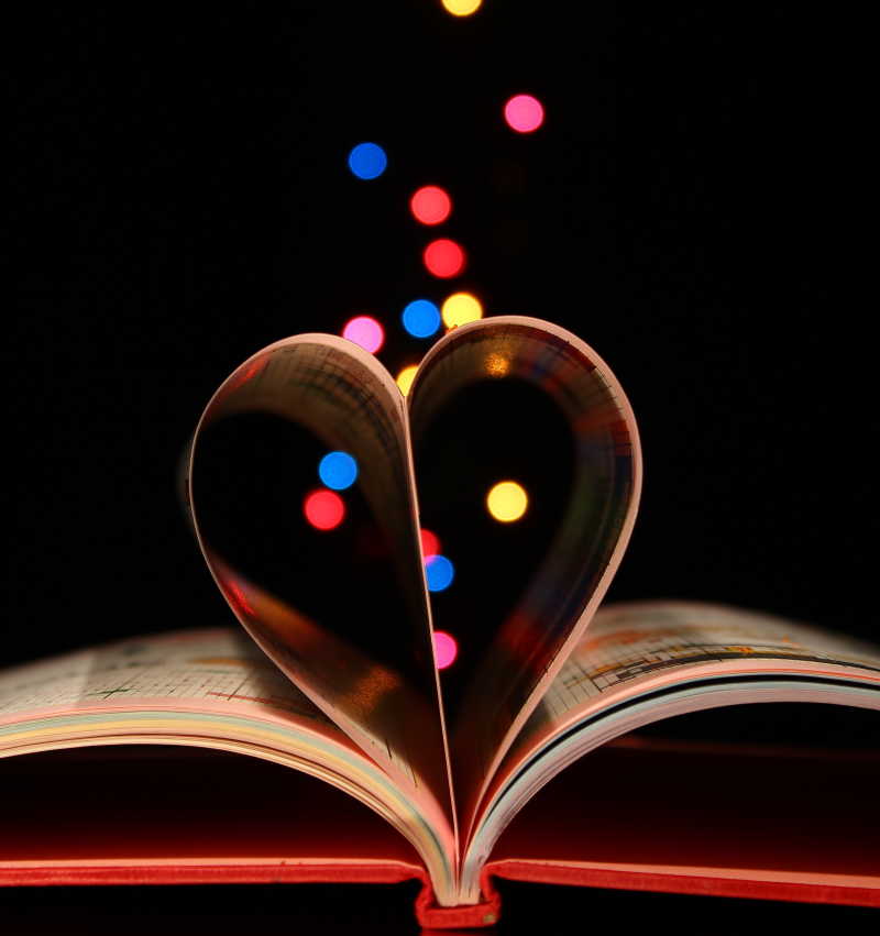 由书页组成立体的心形和各种颜色的灯光