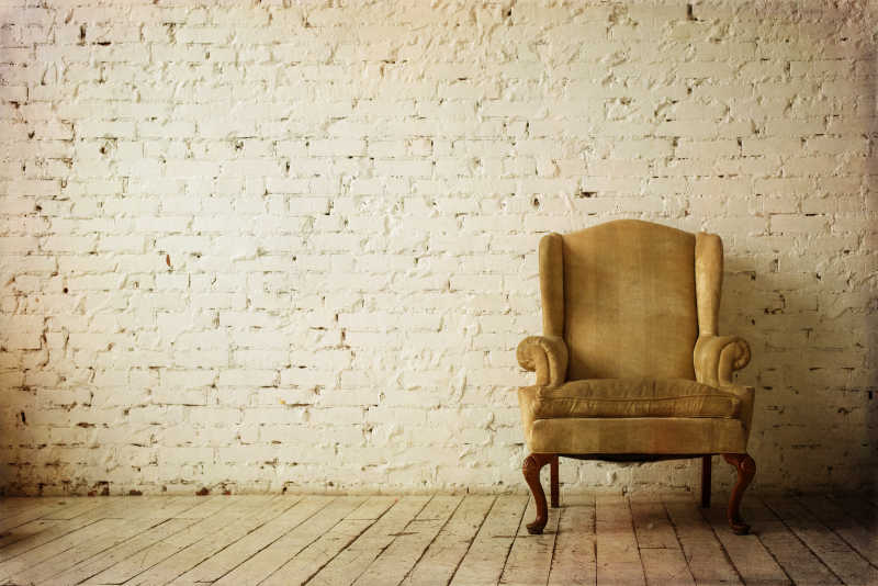 放在砖房里的复古的扶手椅子