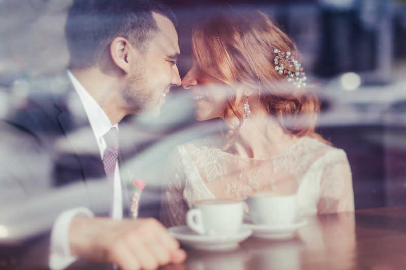 快乐的新郎和新娘喝着咖啡