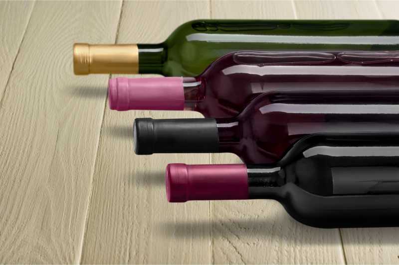 木桌上躺着的葡萄酒瓶