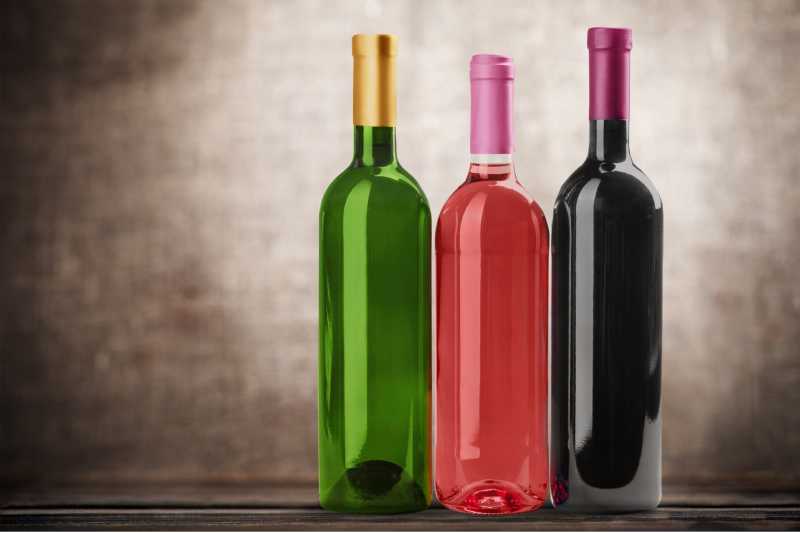 木桌上不同颜色的空的葡萄酒瓶