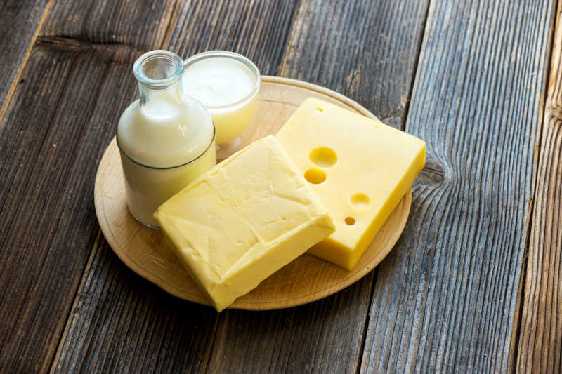 木材背景下盘子里的牛奶和奶酪