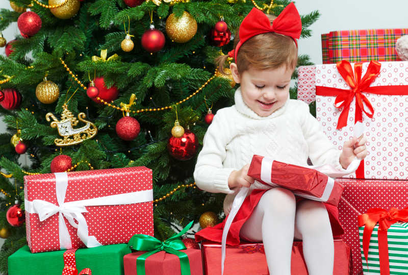 快乐的孩子在圣诞树旁打开圣诞礼物